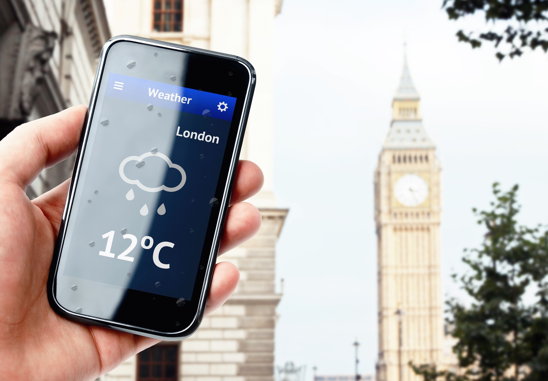 Hand holding smartphone with weather in London